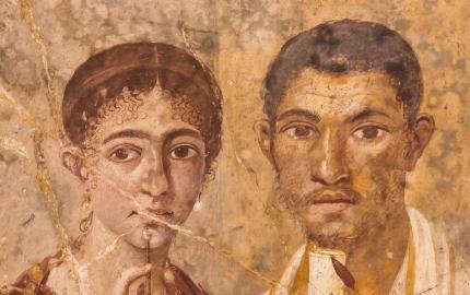 Roman fresco from Pompei depicting a man holding a scroll and a woman holding a stylus and wax tablet.